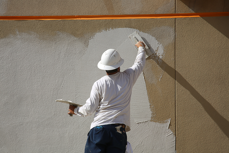 man applying plaster on a textured wall